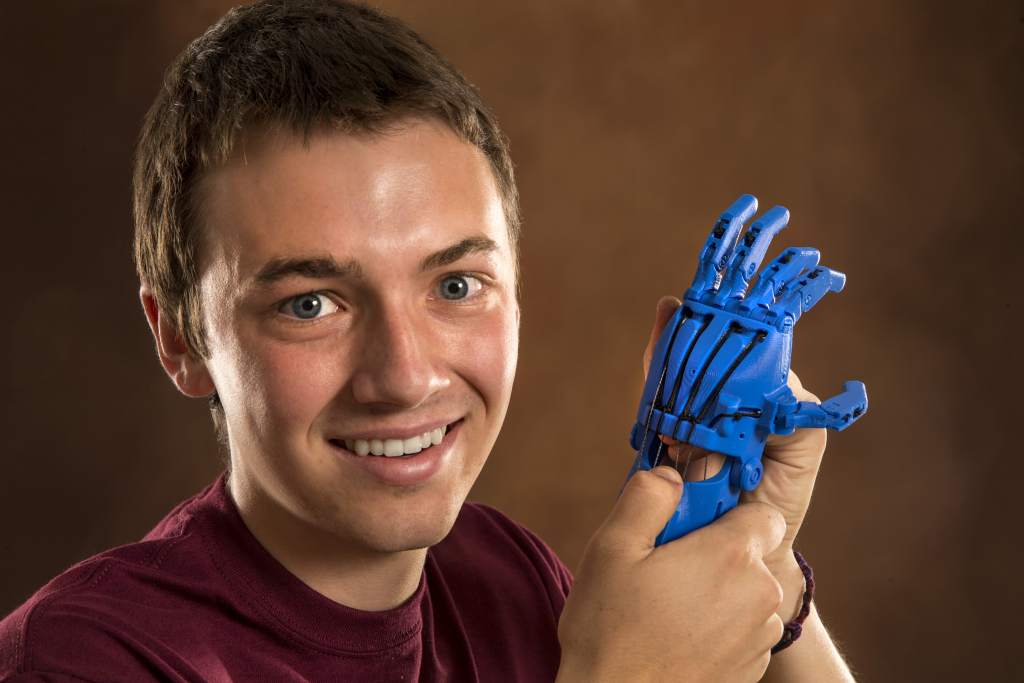 CMU engineering student Austin Brittain holds a prototype of a 3D printed hand he made. Central Michigan University photos by Steve Jessmore